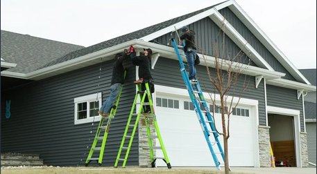 The TiDAL-X crew installing track under an eave by day